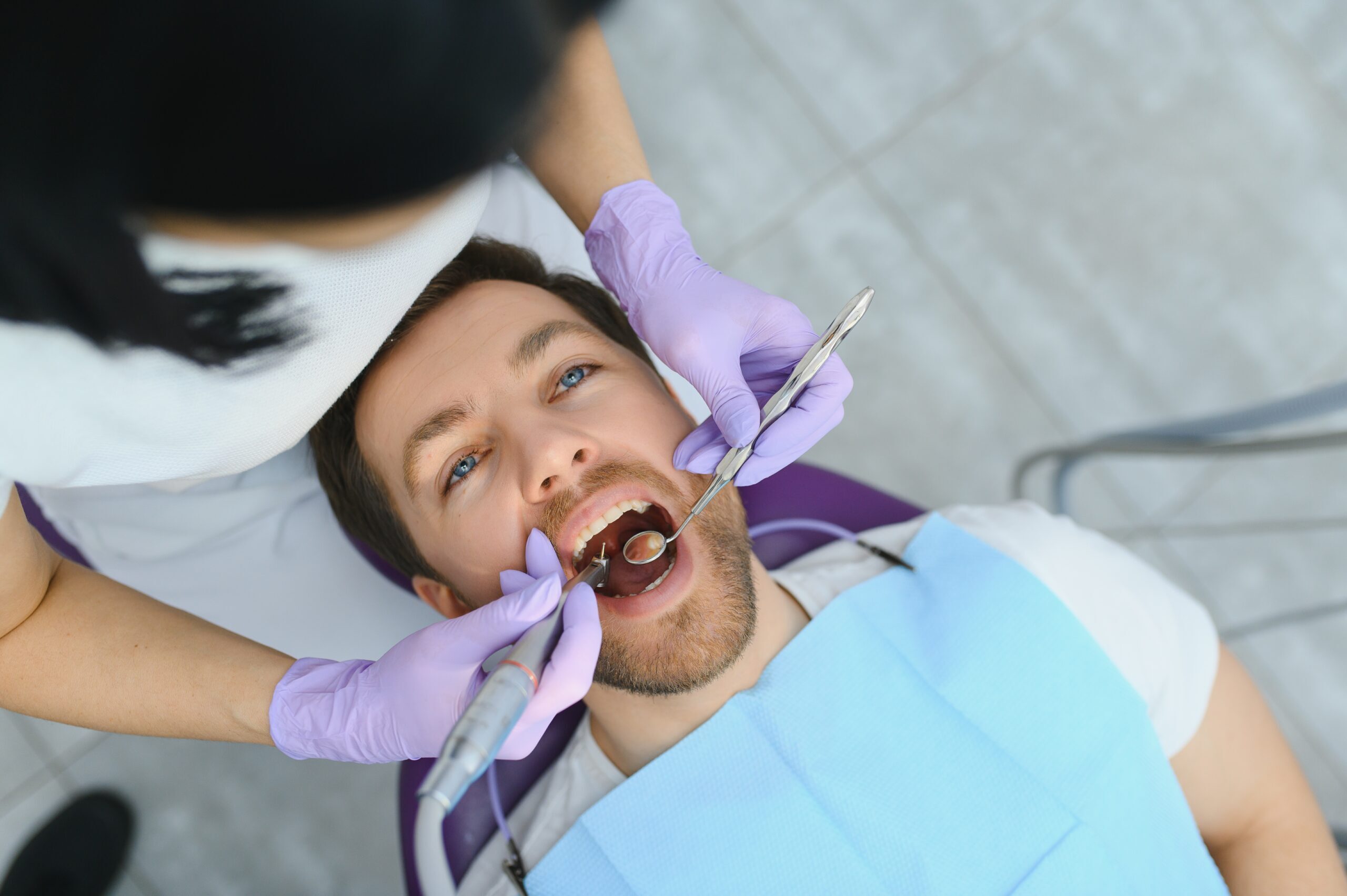 Dentist examining patient's teeth during oral health evaluation at Edinburg dental practice.